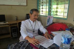 Bro. Bary is making correction the paper work of the student.