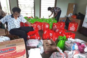 Bro. Hartoko preparing packets of food and others for the needy.