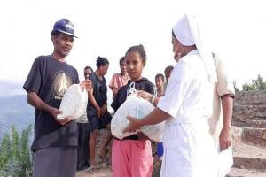 Bro.Zeca is giving a packet of food and others to a girl who live in his neighbourhood